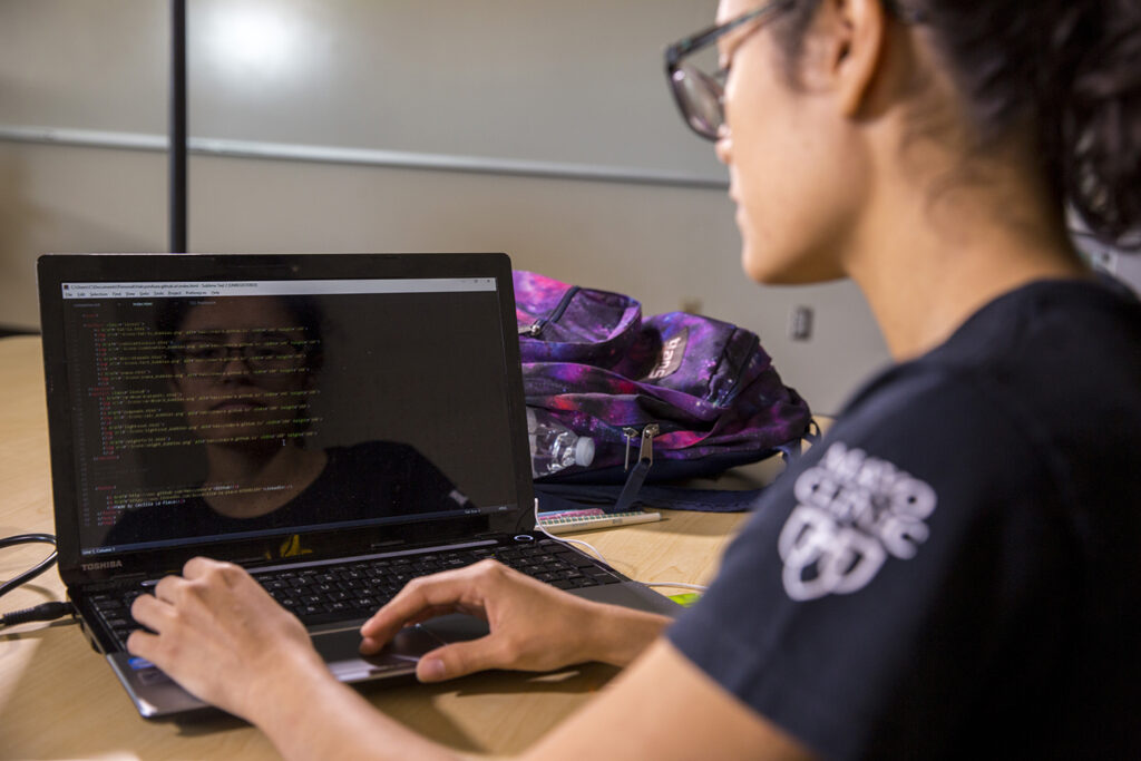 Student engineer Cecilia LaPlace writing code on her laptop for her FURI project